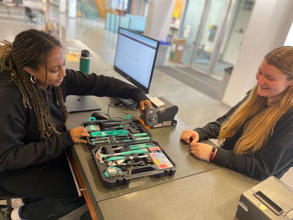 A student worker is pictured scanning a tool box for a student patron. 